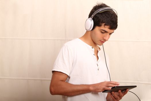 A young, latin man playing with a Tablet PC
