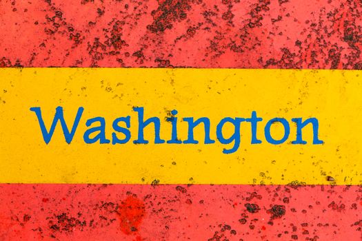 Detail of the word Washington on a newspaper stand that is brightly painted but starting to rust
