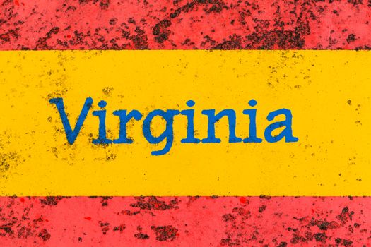 Detail of the word Virginia on a newspaper stand that is brightly painted but starting to rust