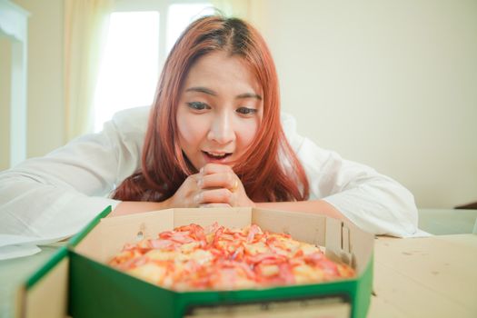 Young asian beautiful woman with pizza at home