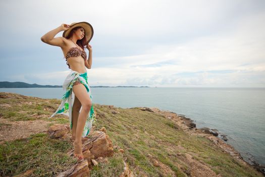 Portrait of sexy young asian woman with hat on mountain and sea