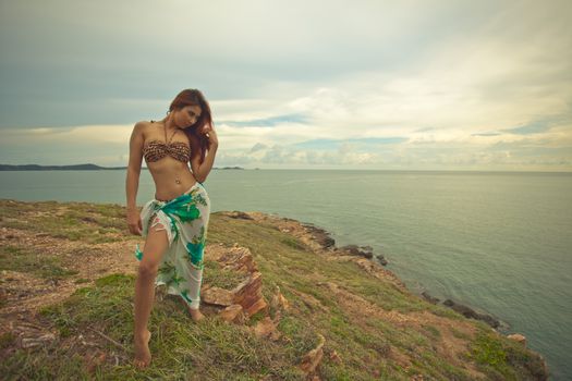 Portrait of sexy young asian woman with hat on mountain and sea