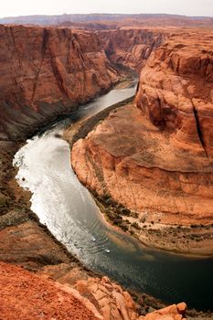 Two boats side by side explore the waters of the Colorado River deep inside the canyon