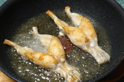 fried frog thighs in a pan