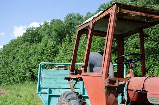 old rustic work tractor in green field outdoor