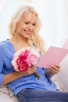 holiday, celebration, home and birthday concept - smiling young woman with greeting card and bouquet of flowers