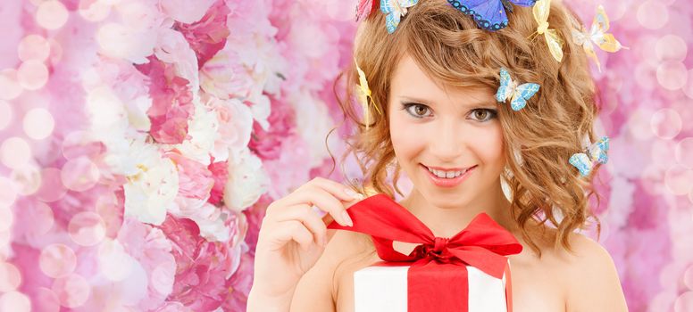 health, holidays and beauty concept - happy teenage girl with butterflies in hair opening gift box