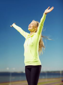 fitness and lifestyle concept - woman doing sports outdoors