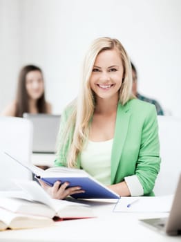 education concept - picture of smiling young woman reading book at school