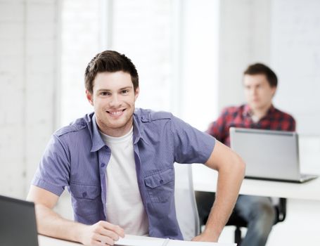 education concept - group of smiling students with laptops at school