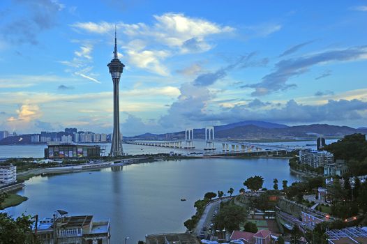 Urban landscape of Macau with famous traveling tower under blue sky near river in Macao, Asia.