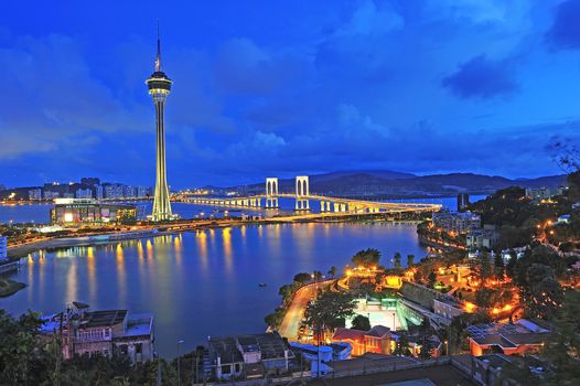 Urban landscape of Macau with famous traveling tower under blue sky near river in Macao, Asia.