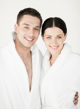 healthcare and beauty concept - picture of couple in spa salon in white bathrobes