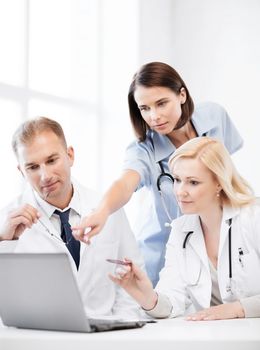 healthcare, medical and technology - group of doctors looking at laptop on meeting