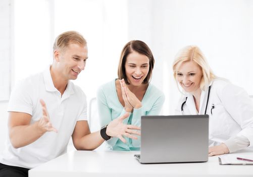 healthcare, medical and technology - doctor with patients looking at laptop