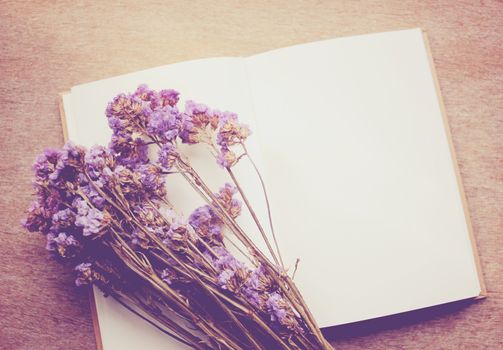 Blank notebook and dried statice flowers with retro filter effect