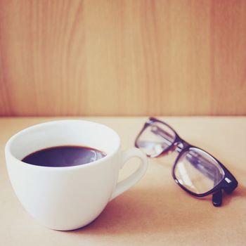 Hot coffee and eyeglasses with retro filter effect