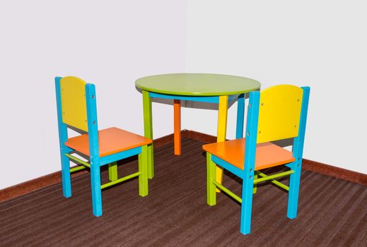 two small school chairs and table in fresh green blue and red