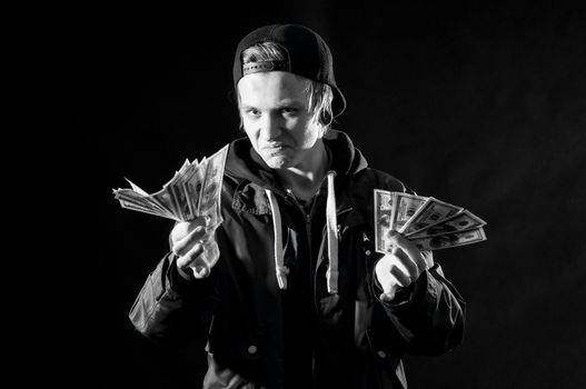 a young man with money in hands on dark background