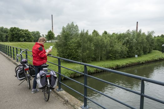 woman with bike is looking on the map searching the right way to go