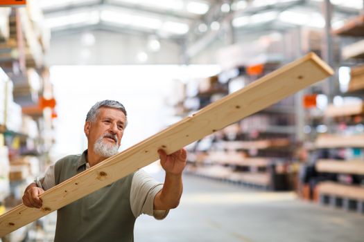 Man buying construction wood in a  DIY store for his DIY home re-modeling project