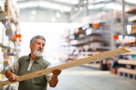 Man buying construction wood in a  DIY store for his DIY home re-modeling project