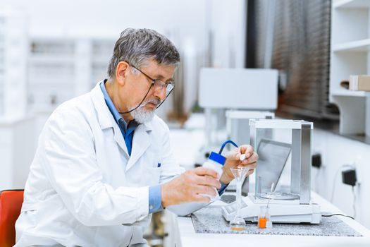 Senior male researcher carrying out scientific research in a lab (shallow DOF; color toned image)