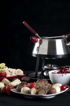 Fondue melted chocolate dip with different flavors on black background