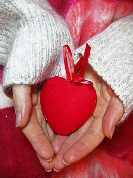 Valentine red heart in woman tender hands