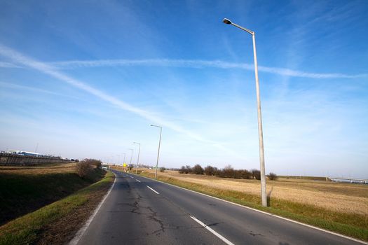 Asphalt road with lamps beside