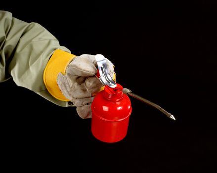 hand of a worker holding a red oiler