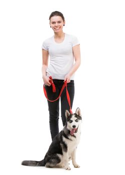 portrait of happy girl in white t-shirt and black trousers isolated on white background and husky dog