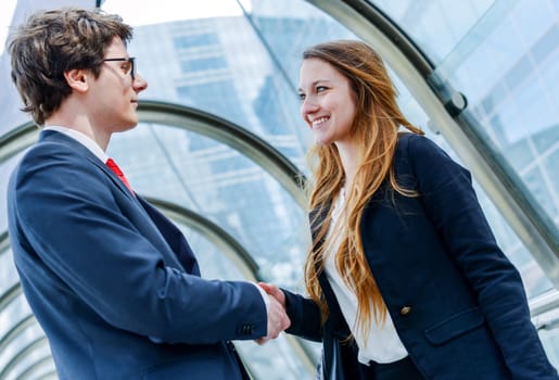 Junior executives dynamics shaking hands