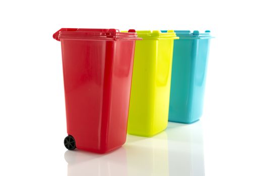 red blue and yellow green garbage bin isolated on white
