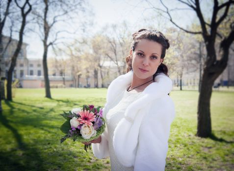 beautiful young bride with a bouquet in a Park in spring
