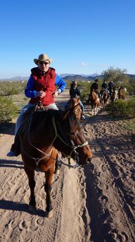 ARIZONA, USA - FEBRUARY 04, 2014: Visitors ride on the hourse back at Arizona, USA. Horseback riding is the best way to enjoy the beauty of Arizona.