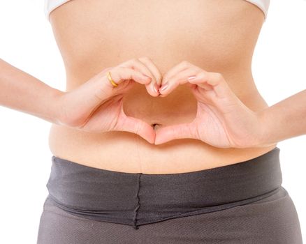 Woman making heart shape with her hands on her stomach