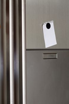 Blank paper and magnet on refrigerator door. 