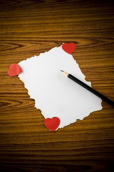 white paper with pencil and red heart on wooden background concept for valentine day