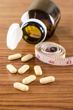 pills and measuring tape concept diet with drug