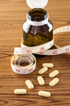 pills and measuring tape concept diet with drug