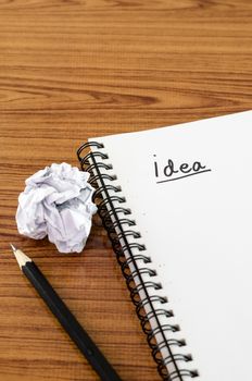 crumpled paper and pencil with notebook write idea word on wood background