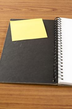 open notebook with post it on wood background