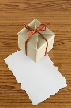 gift box with paper write your note on wood background
