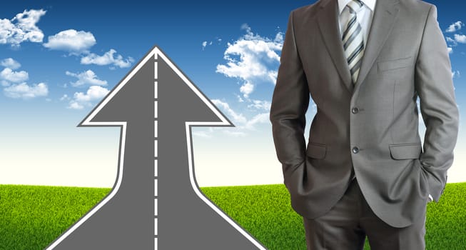 Businessman wearing suit. Road climbs up. Field of grass and sky as background