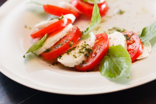 Tomato and mozzarella with basil leaves 