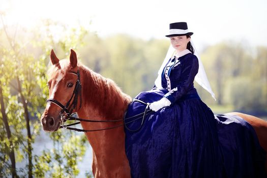 Lady on a  horse. The lady on riding walk. Portrait of the horsewoman. The woman astride a horse. The aristocrat on riding walk.