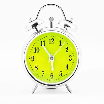 Alarm clock on white background. Showing time five minutes before six