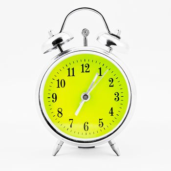 Alarm clock on white background. Showing time five minutes past seven