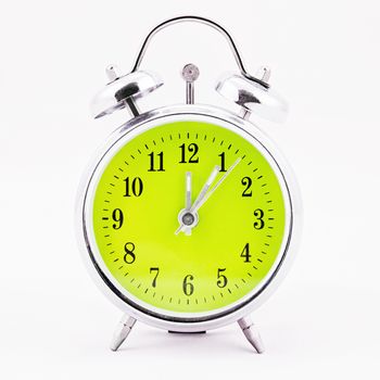 Alarm clock on white background. Showing time five minutes past twelve